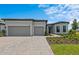 Charming single-story home showcasing a manicured lawn, paved driveway, and a spacious three-car garage at 5958 Talon Preserve Dr, Nokomis, FL 34275
