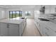 Well-lit kitchen featuring an expansive island, sleek countertops, and stainless steel appliances at 5958 Talon Preserve Dr, Nokomis, FL 34275