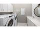 Well-organized laundry room featuring a washer, dryer, utility sink, and storage cabinets at 5958 Talon Preserve Dr, Nokomis, FL 34275