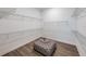 Spacious walk-in closet with custom shelving and a stylish ottoman at 5958 Talon Preserve Dr, Nokomis, FL 34275