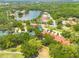 Beautiful aerial view of a residential property with lake frontage surrounded by lush greenery at 60 Woodridge Cir, Oldsmar, FL 34677