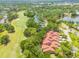 An aerial view of the property highlighting its location next to a golf course, lake, and community at 60 Woodridge Cir, Oldsmar, FL 34677