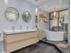 Modern bathroom featuring a double vanity, soaking tub, and decorative lighting at 60 Woodridge Cir, Oldsmar, FL 34677