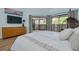Bright bedroom featuring a balcony, wood floors, and a large dresser at 60 Woodridge Cir, Oldsmar, FL 34677