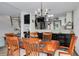 Dining room featuring a wooden table with seating for six, chandelier, and modern black accents at 60 Woodridge Cir, Oldsmar, FL 34677