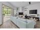 Cozy living room with fireplace, plush sofa, modern entertainment center, and natural light from adjacent sunroom at 60 Woodridge Cir, Oldsmar, FL 34677