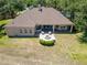 Aerial showcases the home's backyard, patio area with fire pit, and lush, green surroundings at 607 Vintage Way, Brandon, FL 33511