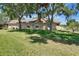 View of the back of the house and lawn, framed by mature trees providing shade and greenery at 607 Vintage Way, Brandon, FL 33511