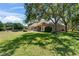 Wide backyard with green grass, trees and outdoor seating at 607 Vintage Way, Brandon, FL 33511