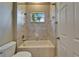 Bathtub and shower combo with tiled walls, along with a toilet, and a door on the right at 607 Vintage Way, Brandon, FL 33511