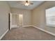 Carpeted bedroom with neutral walls, a ceiling fan, and a window; door leads to another room and closet at 607 Vintage Way, Brandon, FL 33511