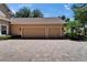 Spacious three-car garage with brick paver driveway and mature landscaping at 607 Vintage Way, Brandon, FL 33511