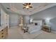 Bright bedroom boasts tray ceiling, fan, neutral carpet, and side tables with lamps at 607 Vintage Way, Brandon, FL 33511