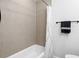 Tiled shower and bath with black towel rack at 716 Lyndhurst St # 702, Dunedin, FL 34698