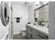 Modern bathroom featuring gray vanity, neutral walls, glass enclosed shower and washer/dryer at 716 Lyndhurst St # 702, Dunedin, FL 34698