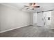 Spacious bedroom with ceiling fan, gray wood-look tile, and an en suite laundry room at 716 Lyndhurst St # 702, Dunedin, FL 34698