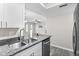 Bright kitchen featuring granite countertops, stainless steel appliances, and a view to the living room at 716 Lyndhurst St # 702, Dunedin, FL 34698