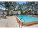 Community pool with mature trees offering shade and seating at 716 Lyndhurst St # 702, Dunedin, FL 34698