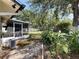 A view of the backyard and sunroom, featuring mature landscaping and a white fence at 809 Scotland St, Dunedin, FL 34698