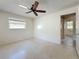 Spacious bedroom with a window, ceiling fan and adjacent bathroom access at 809 Scotland St, Dunedin, FL 34698