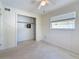 Well-lit bedroom with a ceiling fan, closet, and window providing natural light at 809 Scotland St, Dunedin, FL 34698
