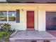 Single Gathering home with red front door, shutters, and a one car garage at 809 Scotland St, Dunedin, FL 34698