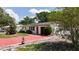 Charming single-story home with bright red driveway, lush landscaping, and a cozy exterior at 809 Scotland St, Dunedin, FL 34698