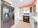 Kitchen featuring stainless refrigerator, range, and countertop, with view to hallway at 809 Scotland St, Dunedin, FL 34698