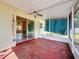 Enclosed patio featuring a ceiling fan, screened windows, and a view into the home at 809 Scotland St, Dunedin, FL 34698