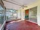A view of the sunroom with a painted floor, screened walls, and a ceiling fan at 809 Scotland St, Dunedin, FL 34698