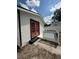 Back exterior of home featuring a small patio with black and white railing and an orange entry door at 1318 W Broad St, Tampa, FL 33604
