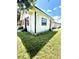 Charming single-story home with white siding, black trim, and an orange door under a partly cloudy blue sky at 1318 W Broad St, Tampa, FL 33604