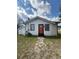 Charming home exterior with walkway, green lawn and inviting orange front door at 1318 W Broad St, Tampa, FL 33604