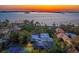 Breathtaking sunset aerial view featuring waterfront homes, lush greenery, and a glimpse of a tennis court at 147 & 139 Edgewater Dr, Dunedin, FL 34698