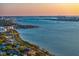 Spectacular aerial view showcasing a stunning bay and a coastal city skyline at sunset at 147 & 139 Edgewater Dr, Dunedin, FL 34698