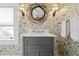 Stylish bathroom with a modern vanity, decorative mirror, and wallpaper at 147 & 139 Edgewater Dr, Dunedin, FL 34698