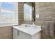 Elegant powder room featuring marble counters, modern fixtures, and designer wallpaper at 147 & 139 Edgewater Dr, Dunedin, FL 34698