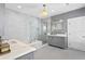 Luxury bathroom with marble tile, glass shower, soaking tub, and double vanity at 147 & 139 Edgewater Dr, Dunedin, FL 34698