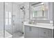 Elegant bathroom with a marble tiled shower featuring glass enclosure, and vanity with marble countertop at 147 & 139 Edgewater Dr, Dunedin, FL 34698