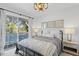 Bedroom with balcony access, neutral color palette, and views of the outdoor pool area at 147 & 139 Edgewater Dr, Dunedin, FL 34698