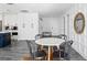 Bright dining area featuring a round table and chairs next to the kitchen with white cabinets at 147 & 139 Edgewater Dr, Dunedin, FL 34698