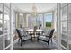Chic dining area with views, showcasing stylish chairs, a crystal chandelier, and bay windows for abundant natural light at 147 & 139 Edgewater Dr, Dunedin, FL 34698