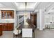 Bright dining room features a large wood table, modern chandelier, and custom cabinets at 147 & 139 Edgewater Dr, Dunedin, FL 34698