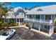Stunning home with white trim, a metal roof, a white convertible, a bike, and manicured landscaping at 147 & 139 Edgewater Dr, Dunedin, FL 34698