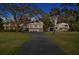 Beautiful home with a long driveway, large trees, and white exterior with a car parked in the driveway at 147 & 139 Edgewater Dr, Dunedin, FL 34698