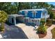 An aerial view showcases this home's inviting courtyard, carport, balcony, and dormer windows, surrounded by lush landscaping at 147 & 139 Edgewater Dr, Dunedin, FL 34698