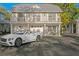 Charming home with a grey exterior, balcony, and a white convertible in the driveway at 147 & 139 Edgewater Dr, Dunedin, FL 34698