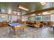 This finished game room features a pool table, vintage decor, wood trim, and unique ceiling, perfect for entertaining at 147 & 139 Edgewater Dr, Dunedin, FL 34698