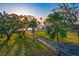 A serene view of lush green space with mature trees, a paved path and glimpse of the water at 147 & 139 Edgewater Dr, Dunedin, FL 34698