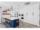 Bright kitchen featuring white cabinets, a blue island, floating shelves and stainless steel appliances at 147 & 139 Edgewater Dr, Dunedin, FL 34698